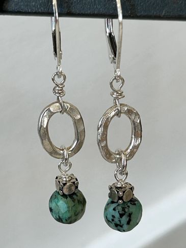 Silver earrings with turquoise beads and textured oval loops.