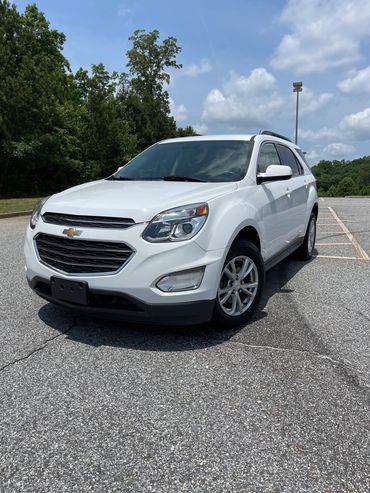 White Chevrolet SUV parked in an empty lot under a partly cloudy sky.
