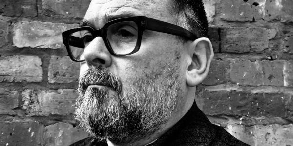 Black and white portrait of a man with glasses and beard.