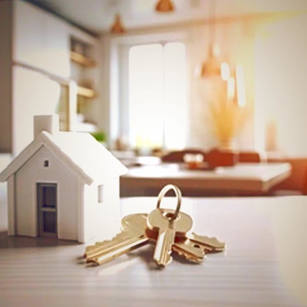 Model house and keys on a table symbolizing homeownership or real estate.