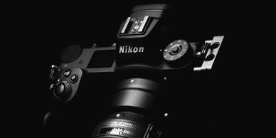 Black and white image of a Nikon camera in low light.