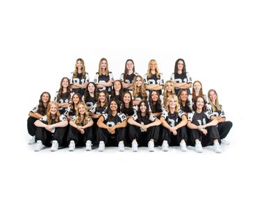 A group of young women in matching black and white sports uniforms posing together.