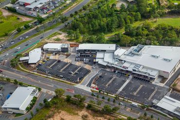Aerial view of a shopping plaza and parking lot.