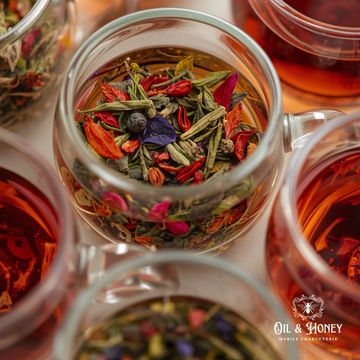 Colorful herbal tea ingredients steeping in glass cups.