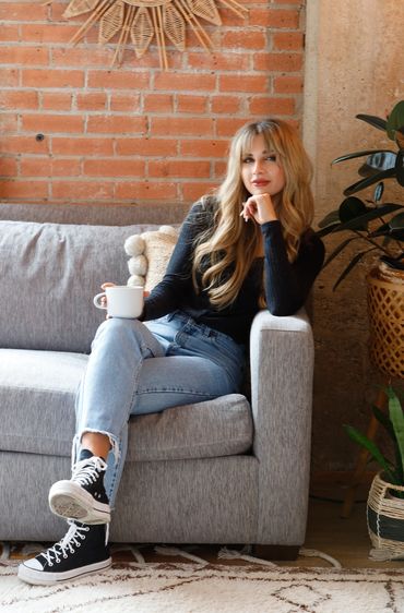 Woman relaxing on a couch with a cup of coffee.