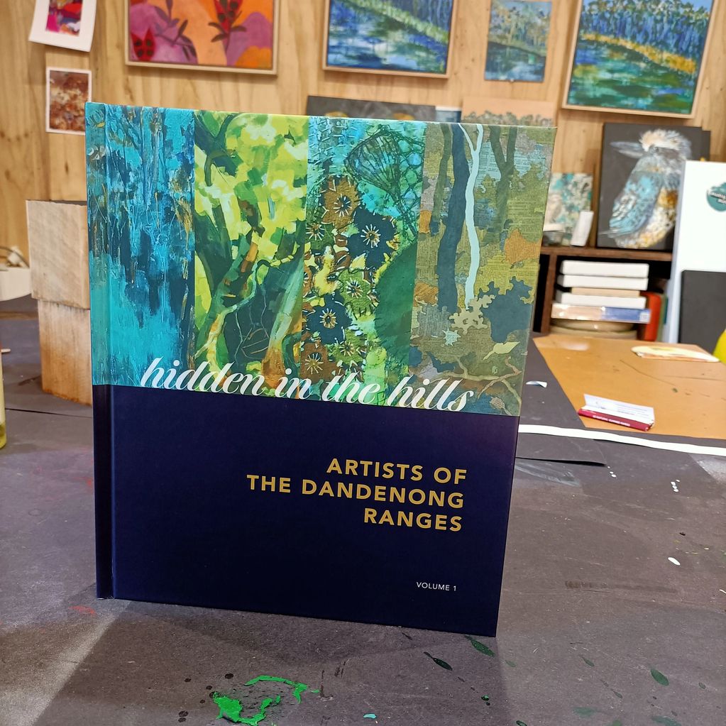 Book titled 'hidden in the hills: Artists of the Dandenong Ranges, Volume 1' with colorful nature-themed cover art.