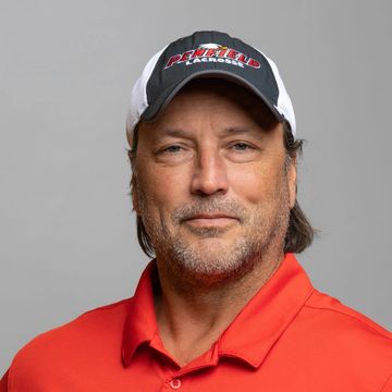 Man wearing a red shirt and a white and black cap.