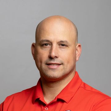 Portrait of a man in a red Penfield Lacrosse polo shirt.