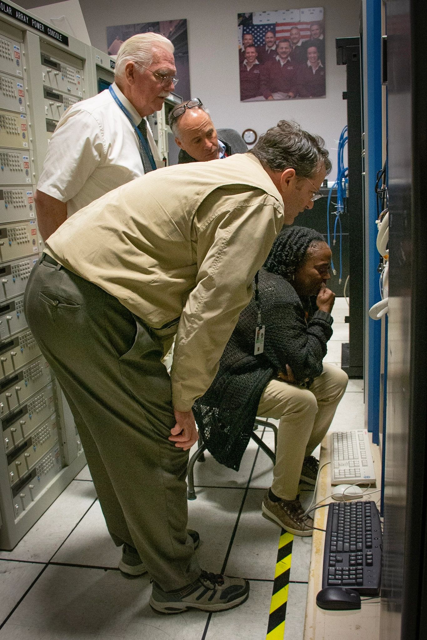 Four people intensely observing technical equipment.