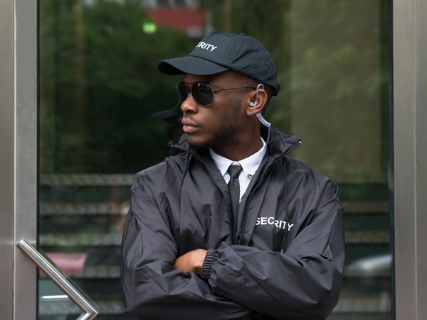 A security guard in front of a building door
