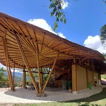 Bamboo pavilion with intricate roof design under a bright sky.