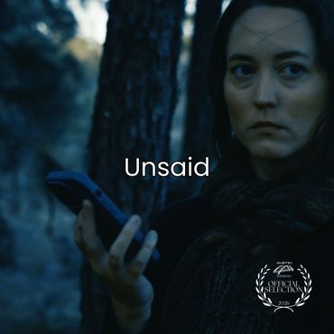 Woman holding a phone with a serious expression in a forest setting.