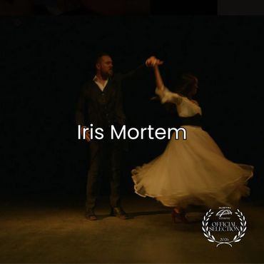 A couple dancing gracefully in a dimly lit space with the title Iris Mortem.
