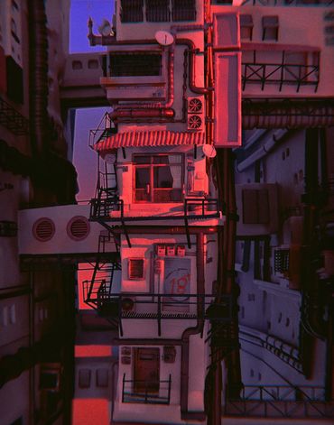 A tall, narrow building illuminated by red and purple lights at dusk.