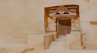 Intricately carved ancient stone doorway with steps leading up.