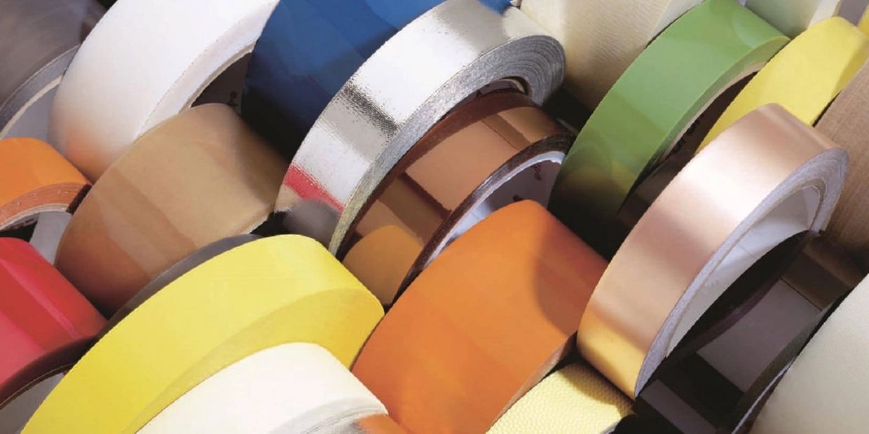 Various colorful rolls of adhesive tape arranged closely together.