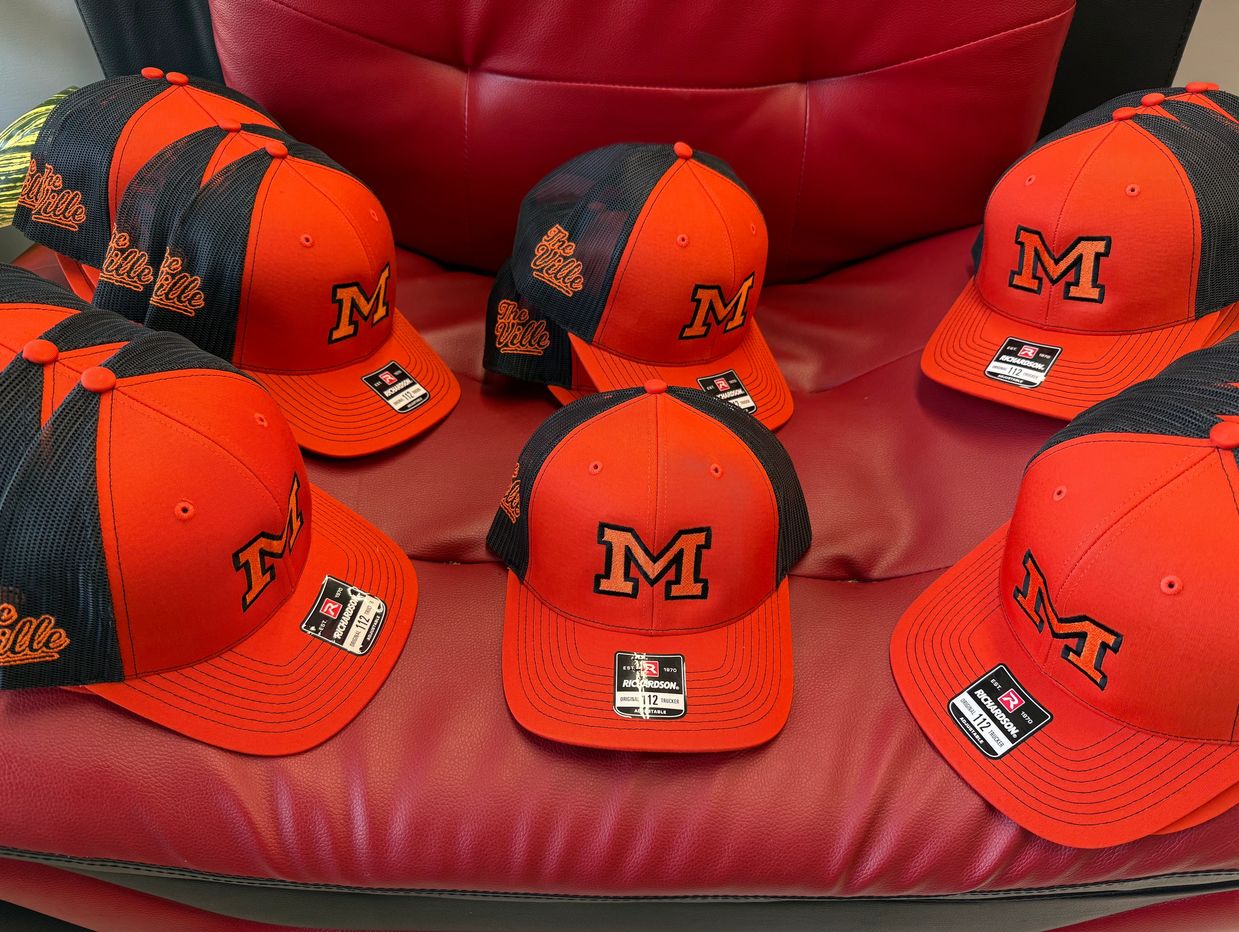 Orange and black baseball caps with "M" and "The Ville".