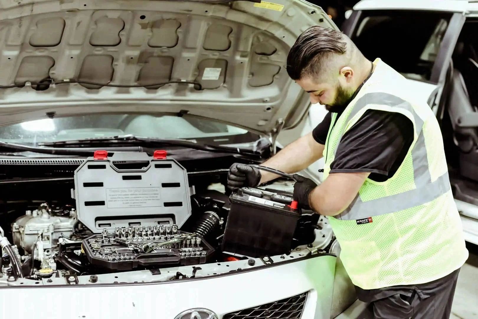 Mechanic replacing car battery.