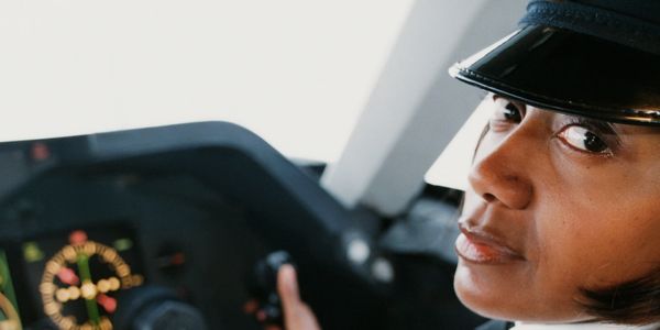 Close-up of a female pilot in uniform inside an airplane cockpit.