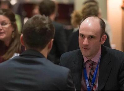 Two men engaged in a serious conversation at an event.