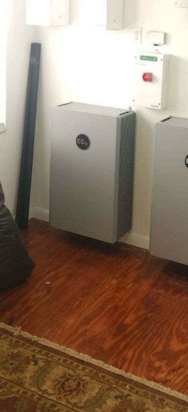Two gray EG4 devices mounted on a wall in a room.