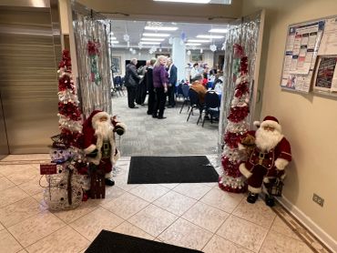 Festive holiday decorations with Santa figures at an office party entrance.