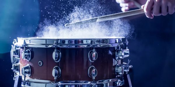 Drumstick hitting snare drum with powder effect.