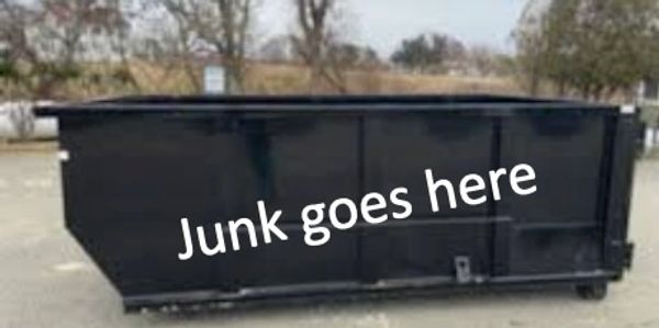 A black dumpster with 'Junk goes here' written on its side.