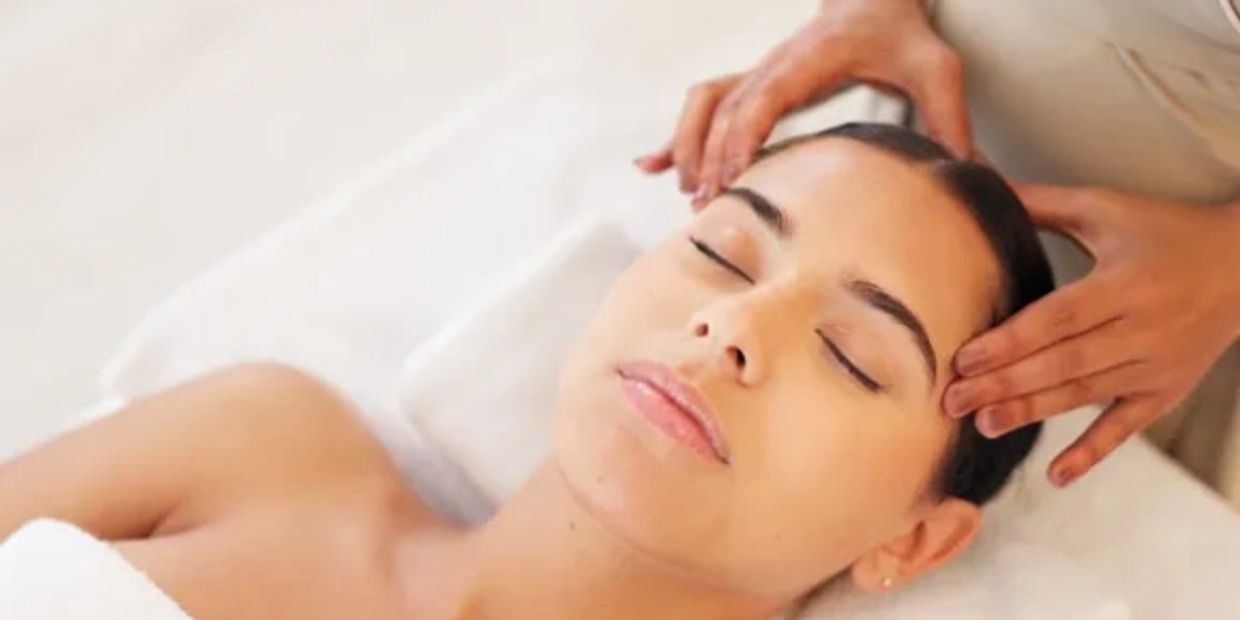 Woman enjoying a relaxing head massage at a spa.