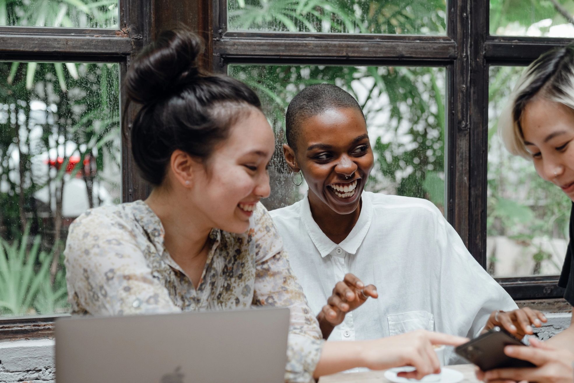 Three women looking at church online. 