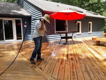 Southern Home Handy-woman removing stain from a wooden deck in Richmond, Virginia, 23220.