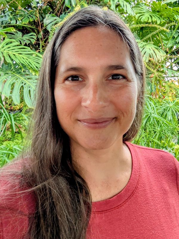 Smiling woman with long hair in a red shirt.