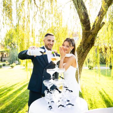 Gelin ve damat, şampanya kulesine şampanya döküyor.