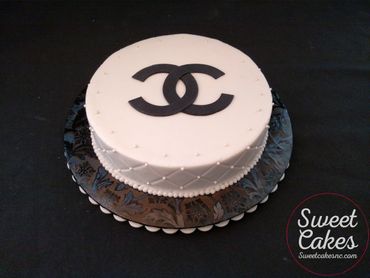 1-layer buttercream iced cake with quilted pattern & sugar pearls on the side, fondant logo on top.