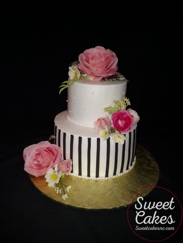 2 tier buttercream icing, silk flowers, fondant stripes