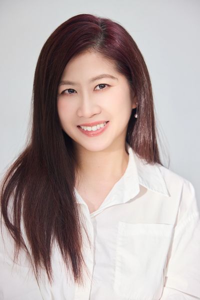 Young woman with long hair smiling warmly.