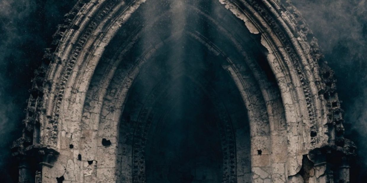 Ancient stone gothic arch with light filtering through.