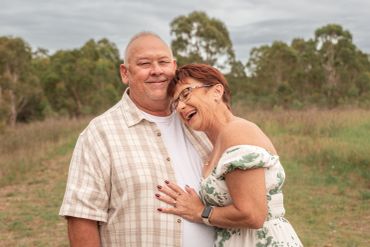 Happy elderly couple embracing outdoors in a natural setting.