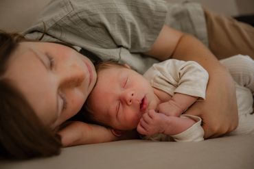 A mother and baby sleeping peacefully together.