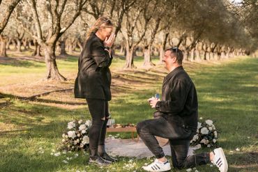 Man proposing to woman in a park.