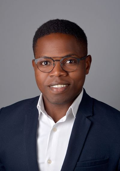 Professional man in glasses with navy blazer and white shirt.