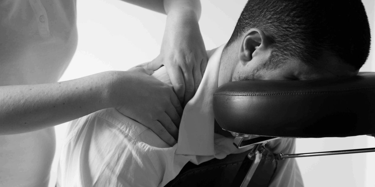 A man receives a chair massage in a corporate environment in Milton Keynes