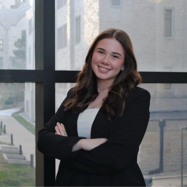 Young woman in business attire smiling confidently indoors.