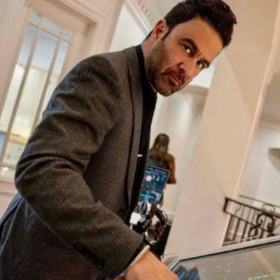 Man in suit interacting with digital screen indoors.