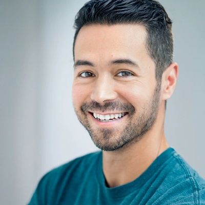 Smiling man with short dark hair and a beard.