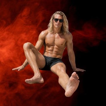 Muscular man with sunglasses posing mid-air against a red smoky background.