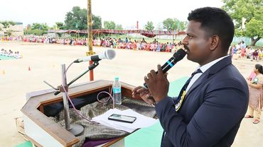 Man speaking at an outdoor event.
