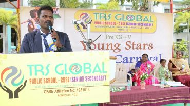 Man speaking at TRS Global Public School event.
