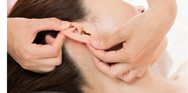 Someone receiving auricular reflexology