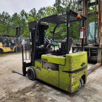 A green Clark forklift parked outdoors on a concrete surface.